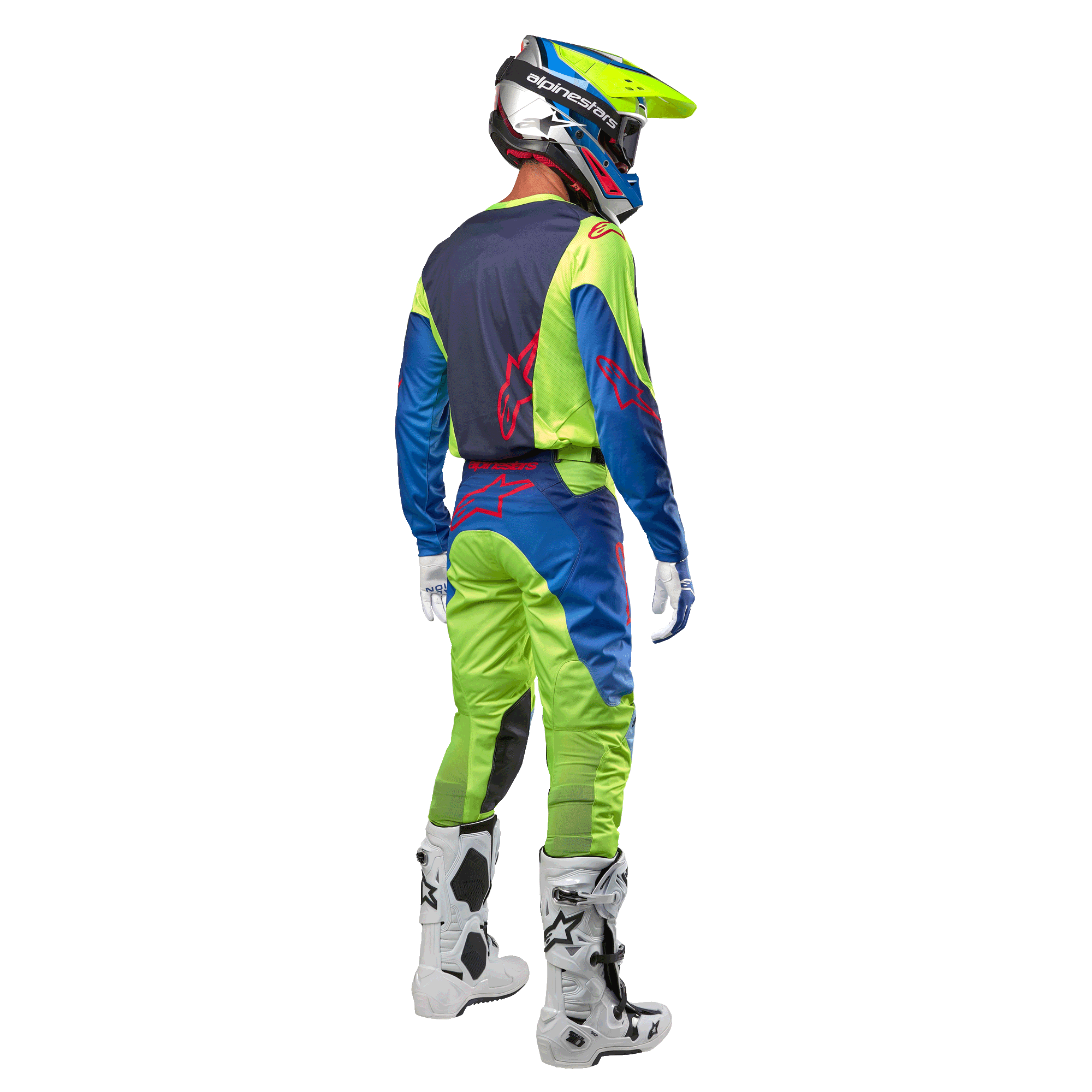 Pilota di motocross visto da dietro con maglia Alpinestars Racer Hoen 2024 in Giallo Fluo e Blu Night Navy, pantaloni da motocross abbinati e stivali bianchi, mostra il design posteriore con loghi rossi, completo coordinato per gare off-road professionali
