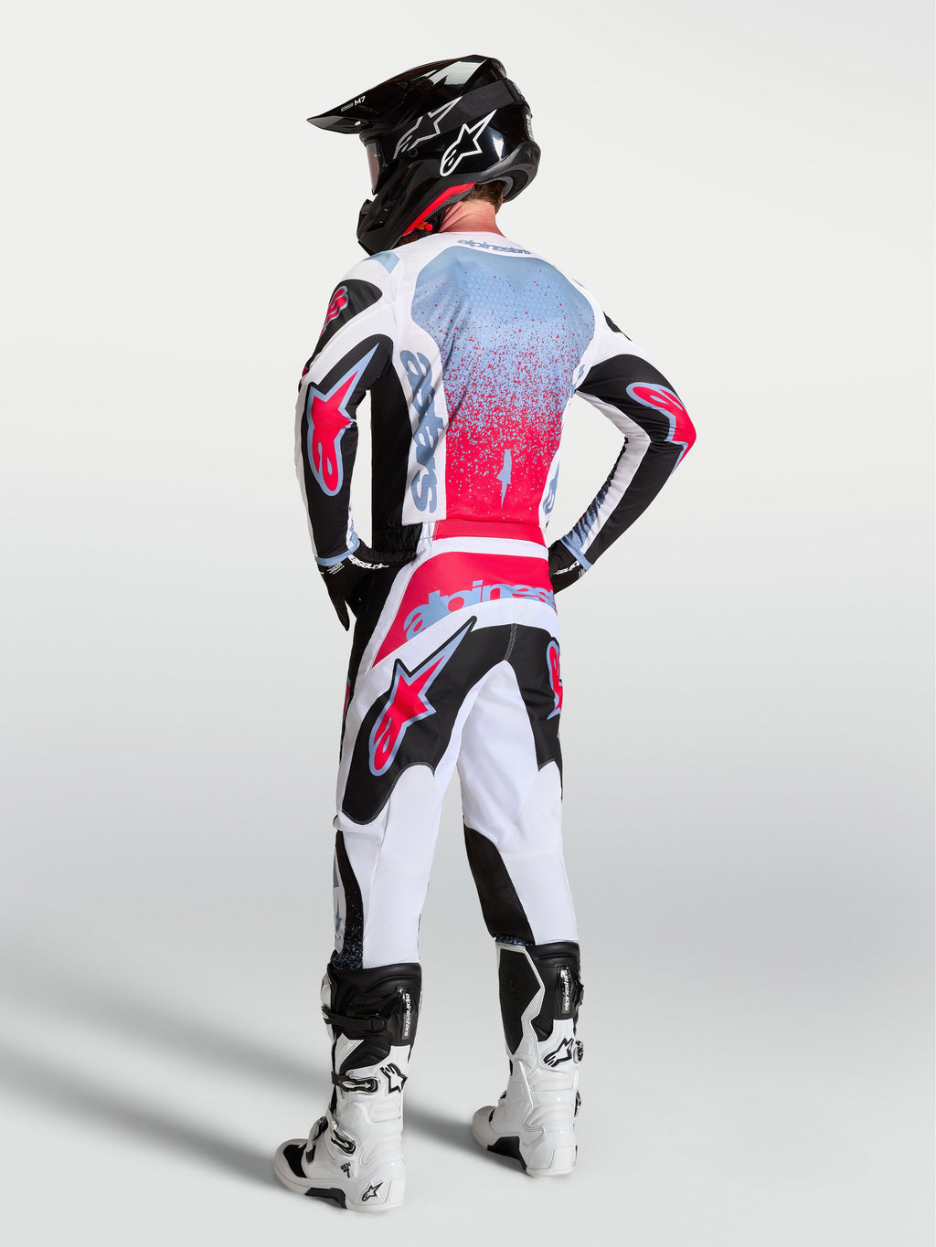 Alpinestars completo MX Fluid Drag 2027, completo da motocross da uomo nero, bianco e rosso con grafiche effetto spray.