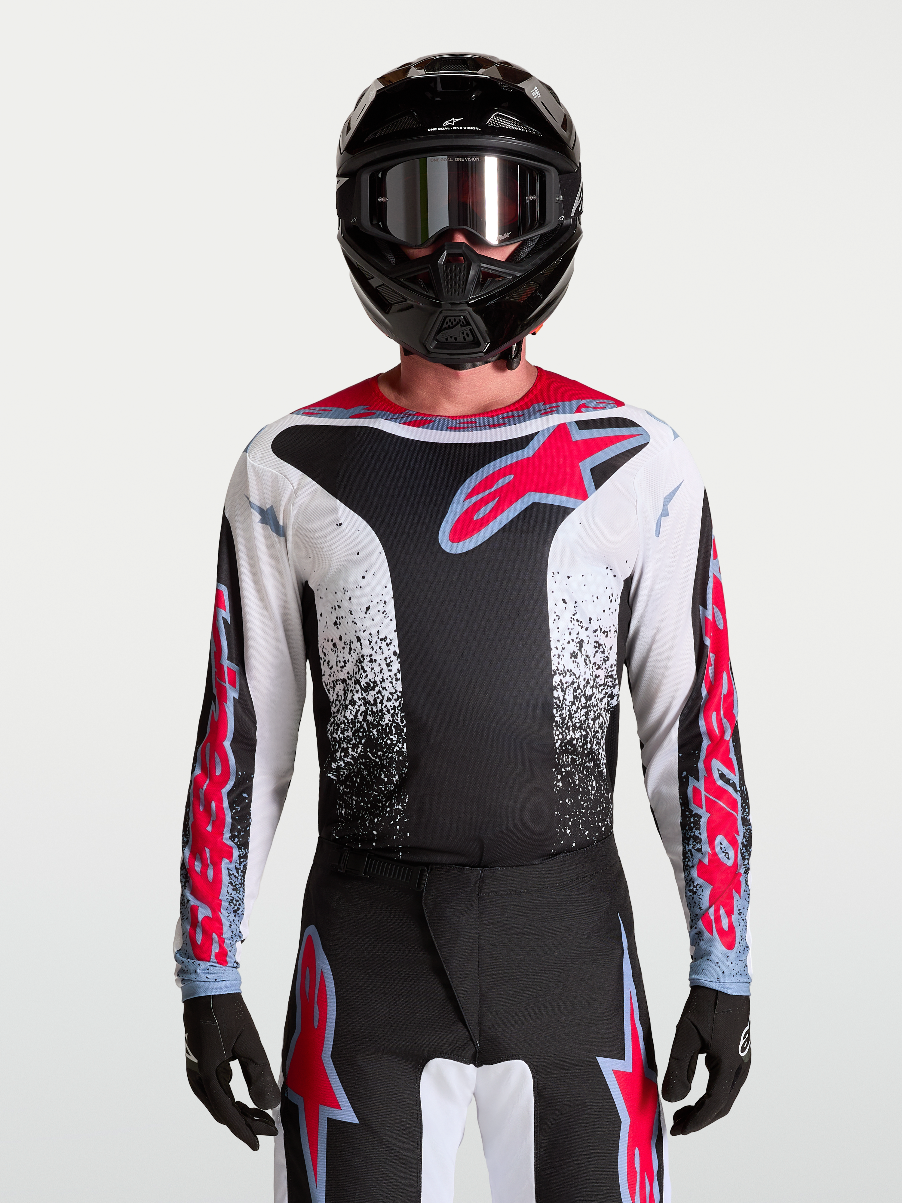 Alpinestars Maglia Fluid Drag, maglia da motocross da uomo, nera e bianca con dettagli rosso fluo, grafica aggressiva, materiale traspirante per off-road, indossata da un pilota
