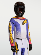 Alpinestars Maglia Fluid Drag, maglia da motocross da uomo, blu e giallo, in tessuto leggero e traspirante per performance fuoristrada, indossata da un pilota con casco e guanti