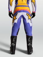Alpinestars Pantaloni Fluid Drag, pantaloni da motocross blu e oro, vista posteriore, con pannelli elasticizzati e seduta rinforzata, abbinati a stivali tecnici neri