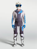 Alpinestars Fluid Drag Gear Set, completo da motocross per uomo, grigio e blu, maglia e pantaloni tecnici da corsa off-road, indossato da un pilota con casco e stivali coordinati.