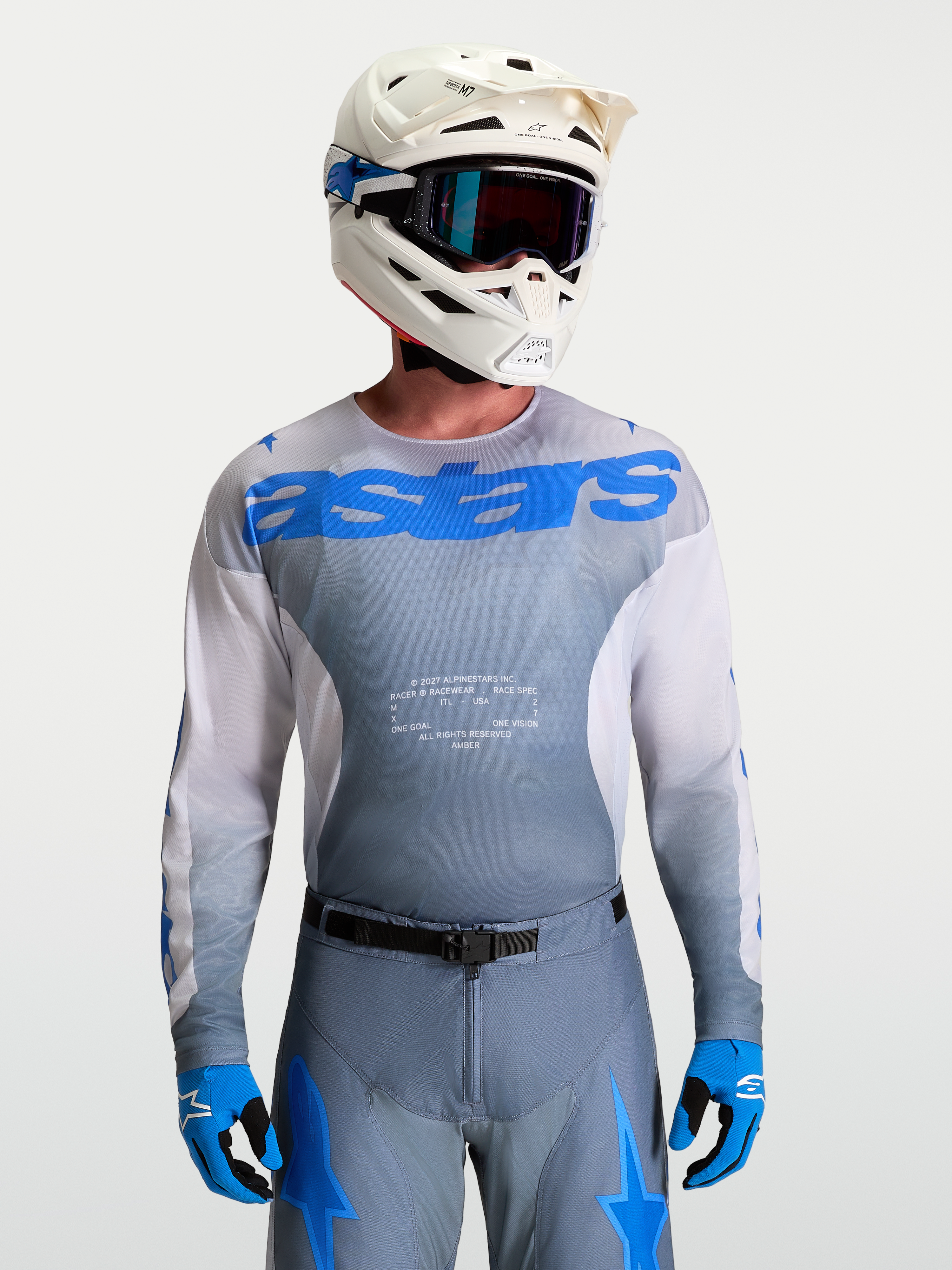 Alpinestars Maglia Racer Amber, maglia motocross da uomo, grigio fumo e blu UCLA, con casco e maschere bianche.
