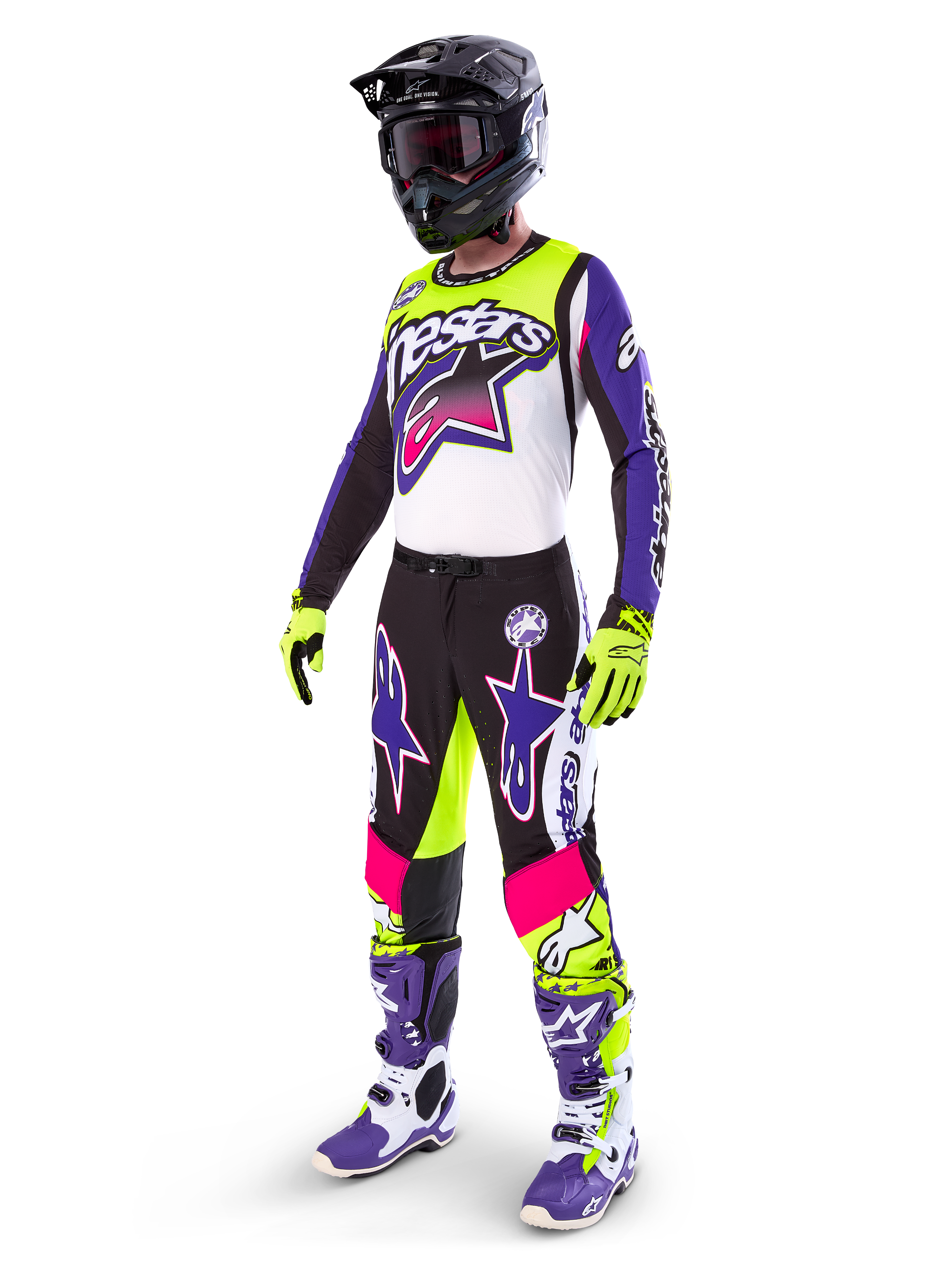 Pilota di motocross che indossa l'abbigliamento Alpinestars Limited Edition Supertech Dirt Studios®, schema colori bianco, viola e giallo fluo, pantaloni neri con grandi loghi a stella viola e rosa, guanti giallo neon, stivali da gara viola e bianchi, casco nero, kit professionale completo per prestazioni off-road