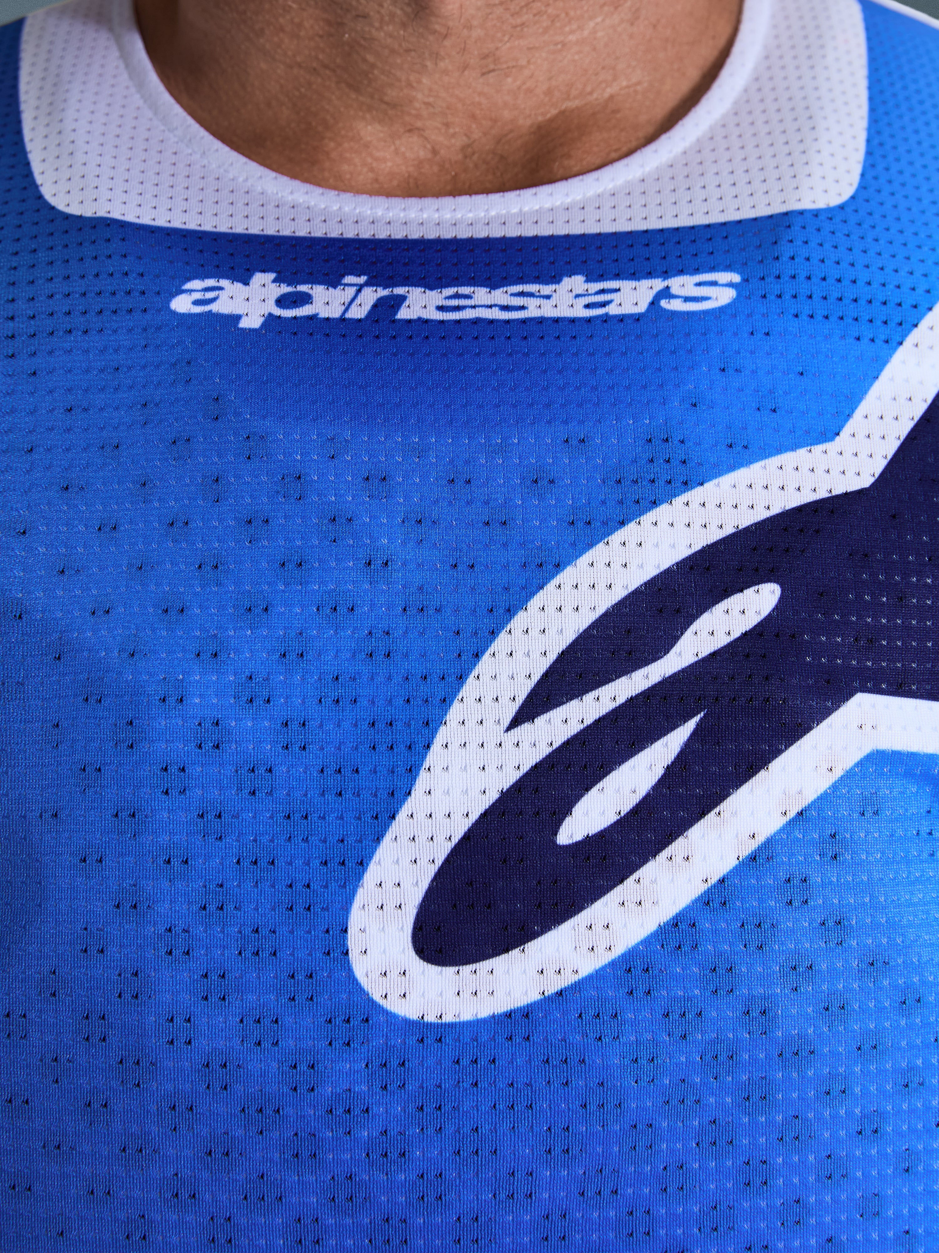 Alpinestars Maglia Racer Air Portl 2026, maglia da motocross, blu UCLA e bianco, vista dettagliata del tessuto in mesh traforato, colletto elasticizzato bianco e logo Alpinestars sul petto