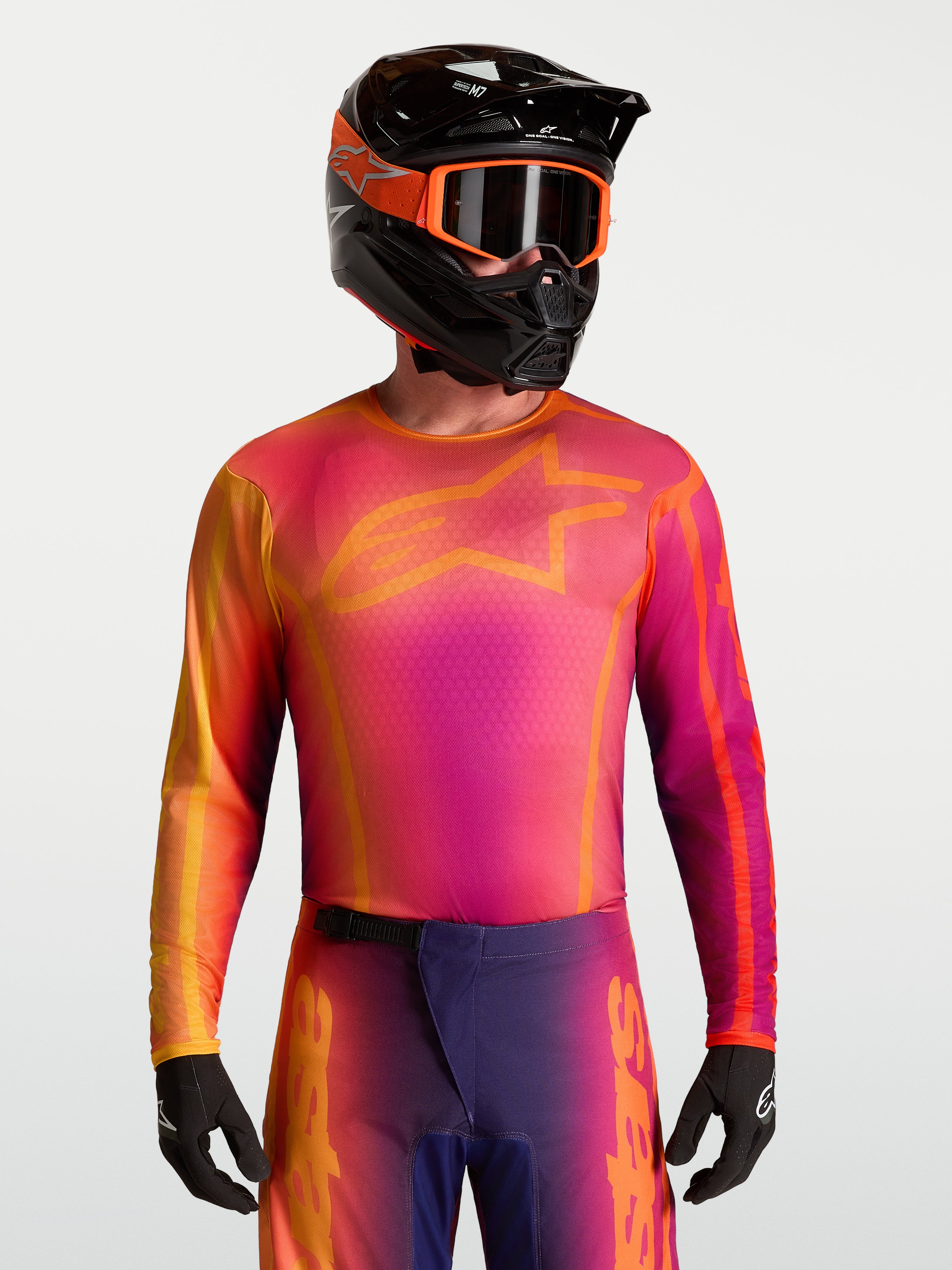 Alpinestars maglia Fluid Kepler, maglia da motocross da uomo, viola e arancione, tessuto traspirante e leggero, vestibilità atletica per fuoristrada, indossata da un modello con casco