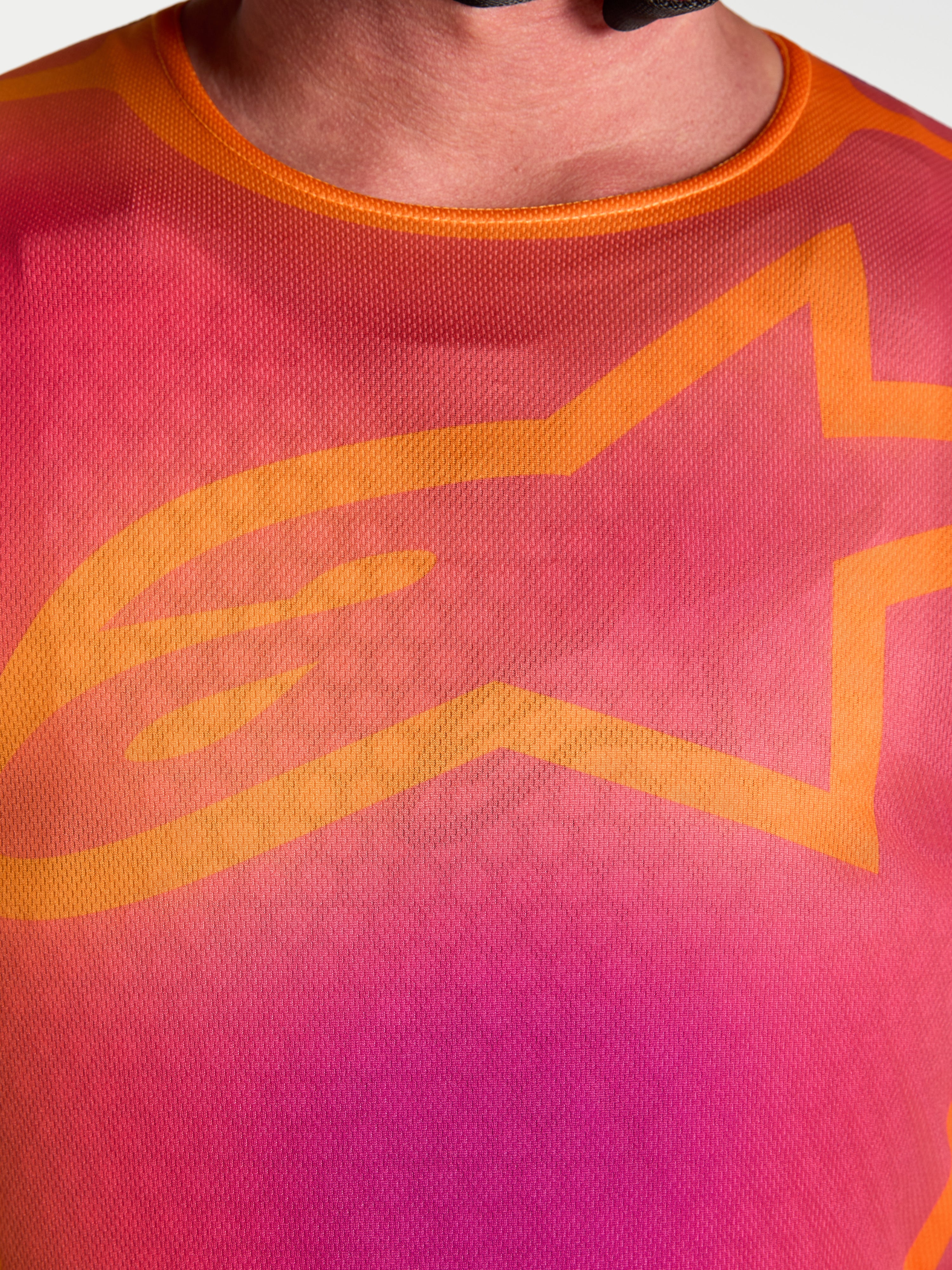 Alpinestars Maglia Fluid Kepler, primo piano del design viola e arancione sul petto con l'iconico logo A-star arancione.