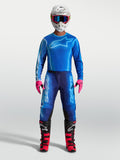 Alpinestars Maglia Fluid Kepler e Fluid Kepler Gear Set, completo da motocross per uomo, blu e rosa, maglia traspirante con vestibilità atletica per guida off-road, indossato su modello con casco e stivali.
