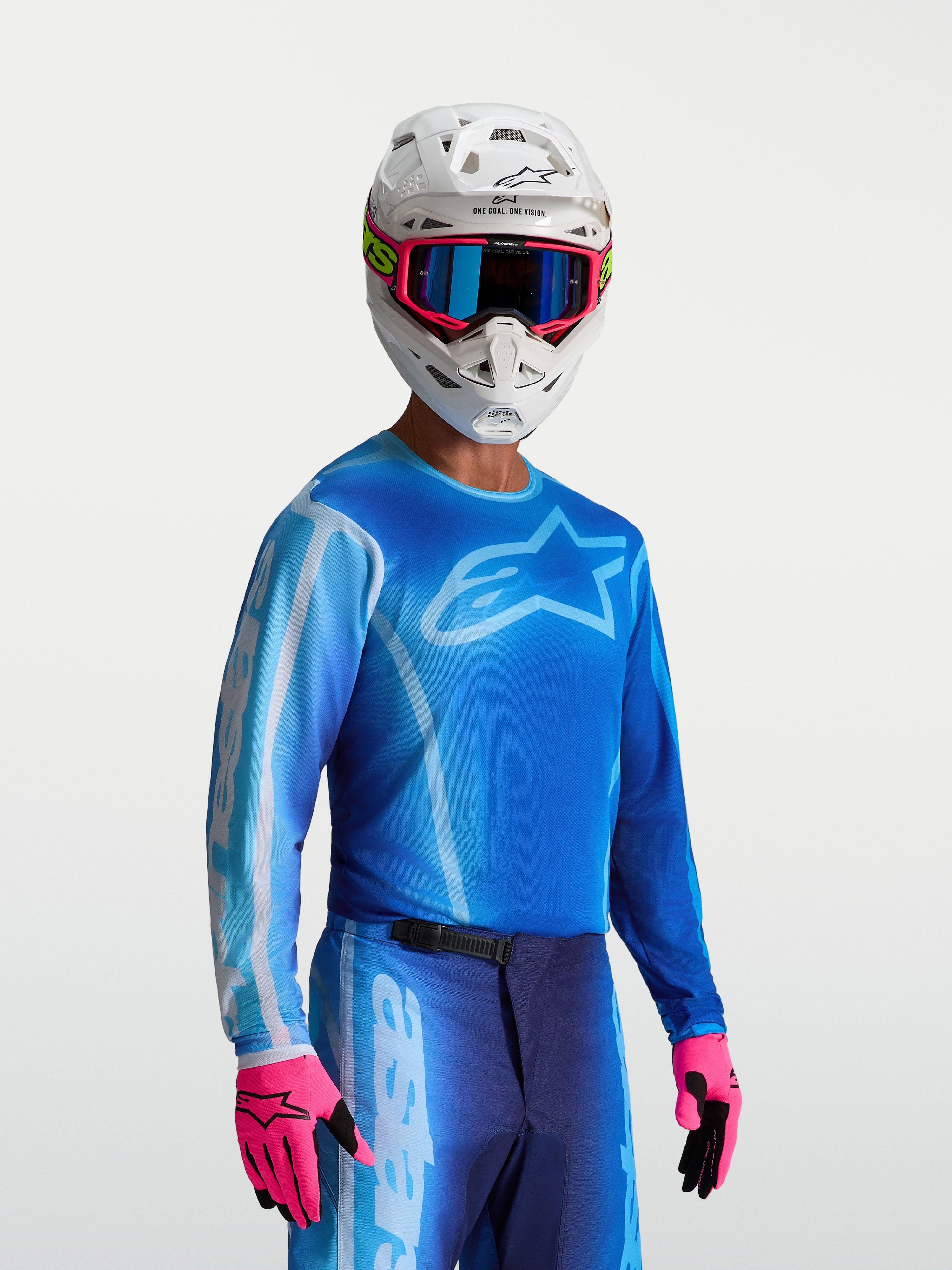 Alpinestars Maglia Fluid Kepler, maglia motocross da uomo, blu UCLA e blu chiaro, indossata con casco bianco e guanti rosa, tessuto traspirante e leggero per motocross e off-road