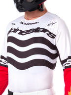 Alpinestars Limited Edition Techstar Deep Jersey, maglia da motocross bianca con strisce orizzontali nere ondulate e maniche rosse, con branding Alpinestars e Techstar, piccole perforazioni tagliate al laser sulla parte superiore del petto per la ventilazione, abbigliamento sportivo da fuoristrada