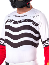 Alpinestars Limited Edition Techstar Deep Jersey, maglia da motocross bianca con strisce orizzontali nere ondulate e maniche rosse, con branding Alpinestars e Techstar, piccole perforazioni tagliate al laser sulla parte superiore del petto per la ventilazione, abbigliamento sportivo da fuoristrada
