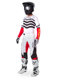 Alpinestars Limited Edition Techstar Deep Gear Set, abbigliamento completo da motocross, maglia bianca con motivi a onde neri e maniche rosse, pantaloni bianchi con dettagli rossi e neri, casco nero con occhiali argento, guanti bianchi e neri, stivali bianchi, completo da gara MX coordinato