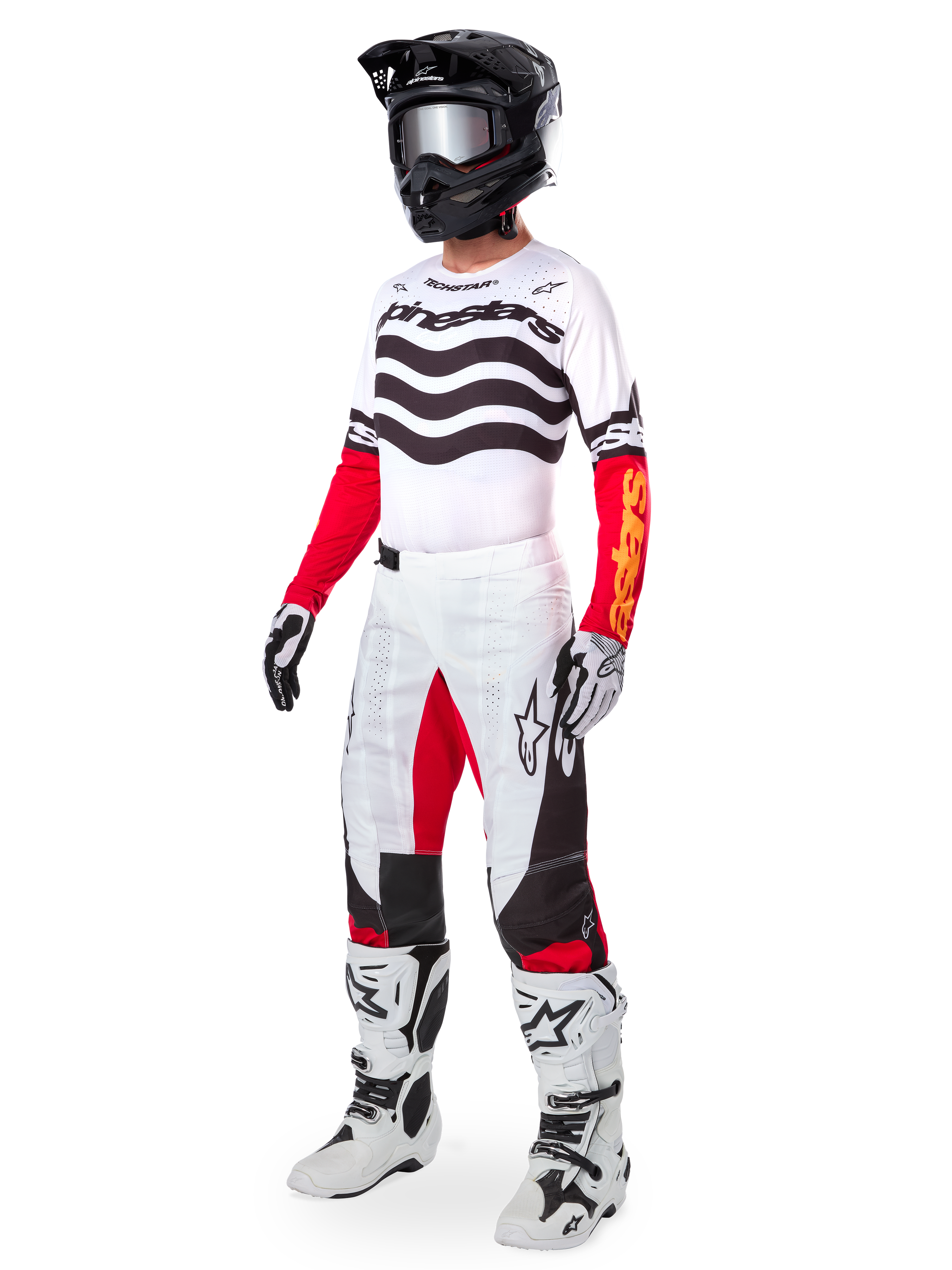 Alpinestars Limited Edition Techstar Deep Gear Set, abbigliamento completo da motocross, maglia bianca con motivi a onde neri e maniche rosse, pantaloni bianchi con dettagli rossi e neri, casco nero con occhiali argento, guanti bianchi e neri, stivali bianchi, completo da gara MX coordinato