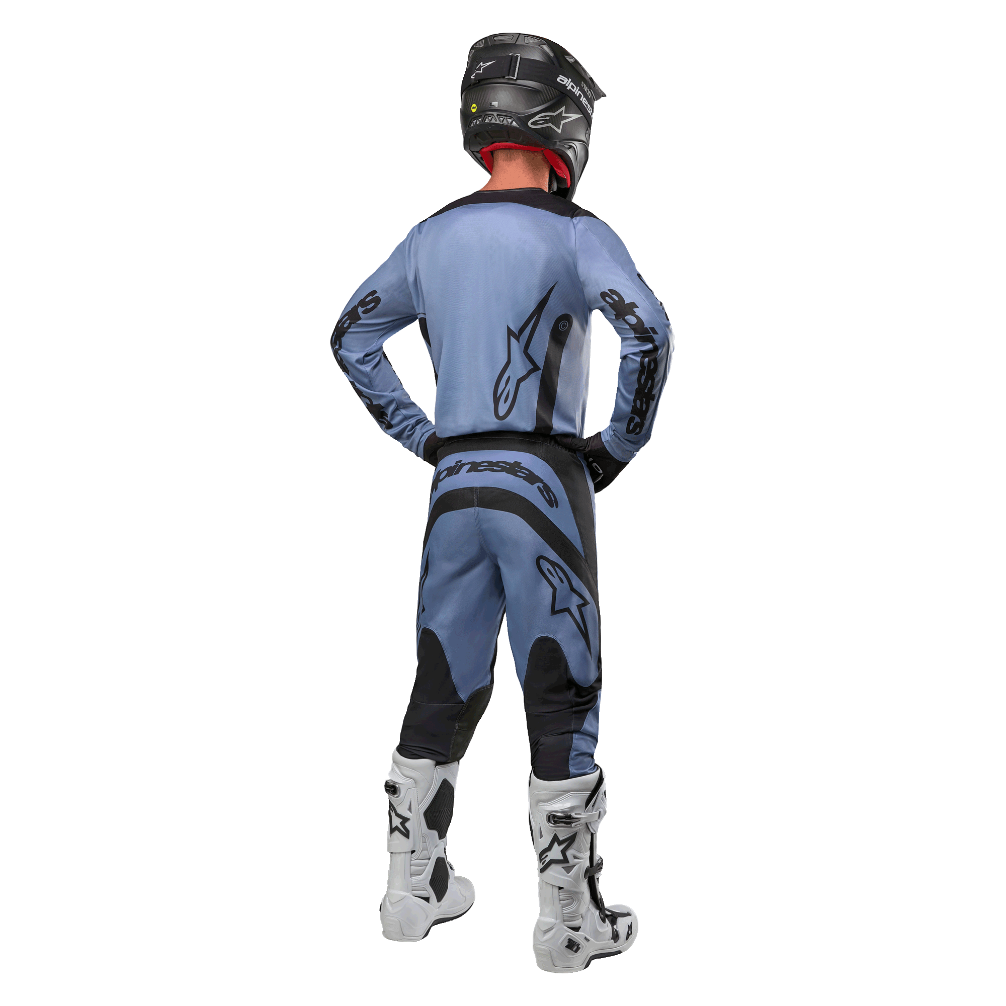Pilota di motocross visto da dietro che indossa la maglia Alpinestars Fluid Lurv 2024 e i pantaloni coordinati in azzurro e nero, con branding nero sul retro e sulle maniche, abbinati a un casco nero e stivali bianchi.