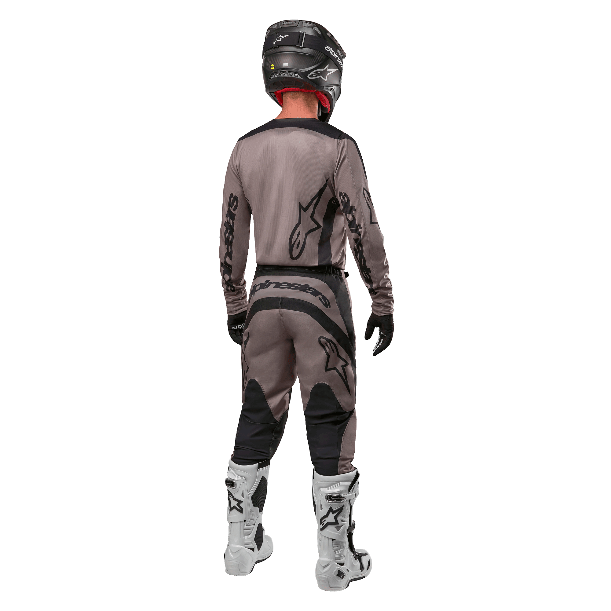 Alpinestars 2024 Fluid Lurv Jersey, maglia da motocross, Mud Black, vista posteriore di un pilota di motocross che indossa un completo da gara coordinato, casco nero e stivali bianchi, con grandi loghi Alpinestars neri e vestibilità atletica per prestazioni off-road.