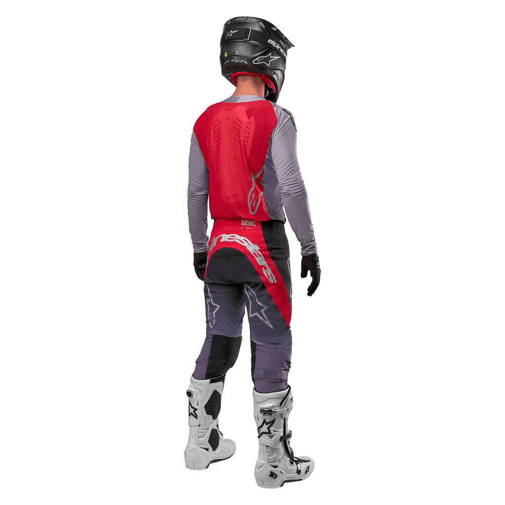 Alpinestars 2024 Supertech Dade Jersey, maglia da motocross, Iron Red Berry e grigio, vista posteriore su un pilota, con pannello posteriore rosso, logo grigio e maniche grigie, indossata con pantaloni da gara coordinati grigi e rossi, stivali bianchi e casco nero, abbigliamento professionale da fuoristrada.