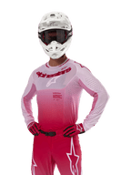 Maglia Alpinestars 2024 Supertech Dade, abbigliamento da gara motocross, design sfumato rosso berry e lilla, maglia a maniche lunghe con perforazioni tagliate al laser, indossata da un pilota con casco bianco e guanti e pantaloni rossi coordinati, kit professionale da motocross su sfondo bianco
