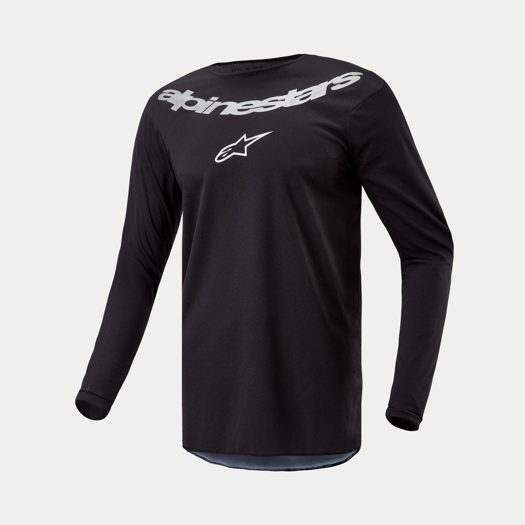 Maglia Alpinestars 2024 Fluid Graphite, maglia da motocross, nero e argento, top tecnico a maniche lunghe con grande marchio Alpinestars e logo a stella argentati sul petto, leggero poli-tessuto traspirante per la guida fuoristrada