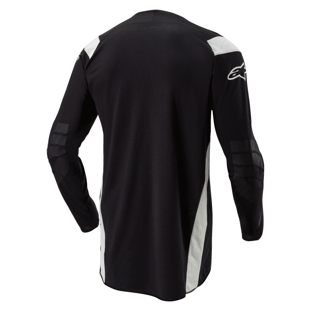 Alpinestars Techdura Jersey, maglia da motocross ed enduro, nera con accenti bianchi, vista posteriore con retro allungato, gomiti rinforzati e logo Alpinestars bianco sulla manica, abbigliamento resistente per la guida off-road.