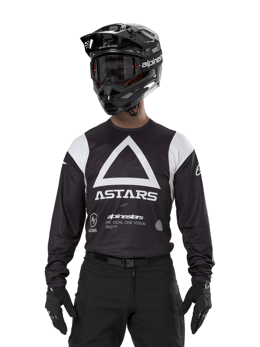 Alpinestars Techdura Jersey, nero, con grande grafica a triangolo bianco sul petto e logo ASTARS, pannelli bianchi sulle spalle, indossata con casco da motocross nero, occhiali e attrezzatura off-road nera coordinata