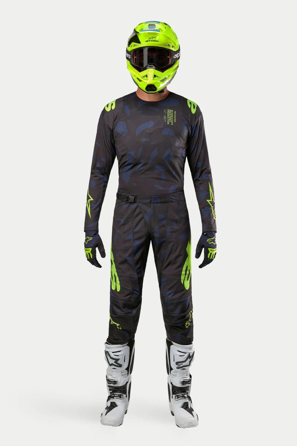 Alpinestars Techstar Rantera 2024, completo maglia e pantaloni da motocross, nero, blu navy e giallo fluo, indossato con casco giallo fluorescente coordinato e stivali bianchi, con branding giallo vivace e pannelli tecnici in mesh per prestazioni fuoristrada