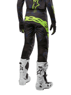Alpinestars 2024 Techstar Rantera Pants, pantaloni da motocross, nero navy e giallo fluo, vista posteriore, con branding giallo neon e pannelli di ventilazione in rete, indossati con maglia coordinata e stivali bianchi, equipaggiamento resistente per motocross e gare fuoristrada