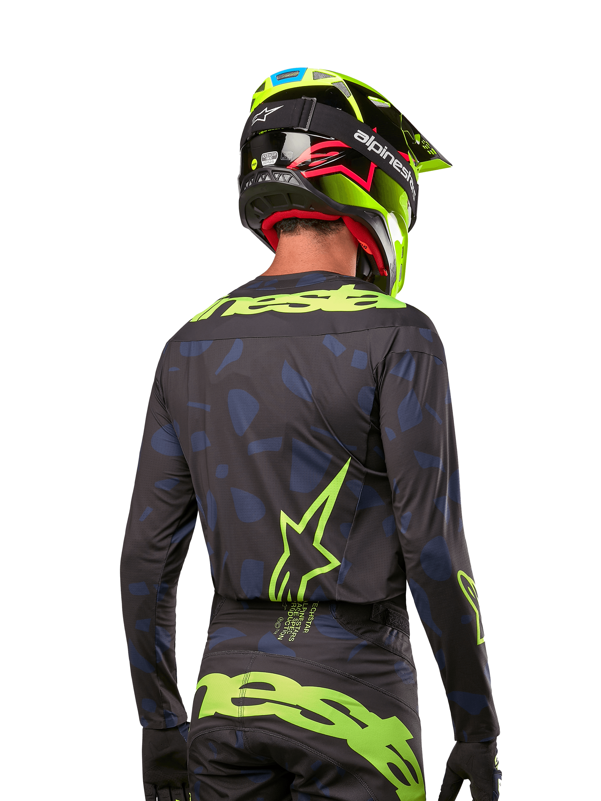 Vista posteriore di un pilota di motocross con maglia Alpinestars 2024 Techstar Rantera in Black Navy Yellow Fluo, caratterizzata da loghi giallo fluo prominenti sulla schiena, abbinata a pantaloni coordinati e casco giallo neon per un look completo da off-road.