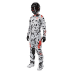 Pilota di motocross con maglia Alpinestars 2024 Techstar Rantera in Haze Gray Camo, pantaloni coordinati con accenti rossi e neri, casco e occhiali neri, guanti neri, stivali bianchi e neri, abbigliamento completo da motocross per prestazioni off-road