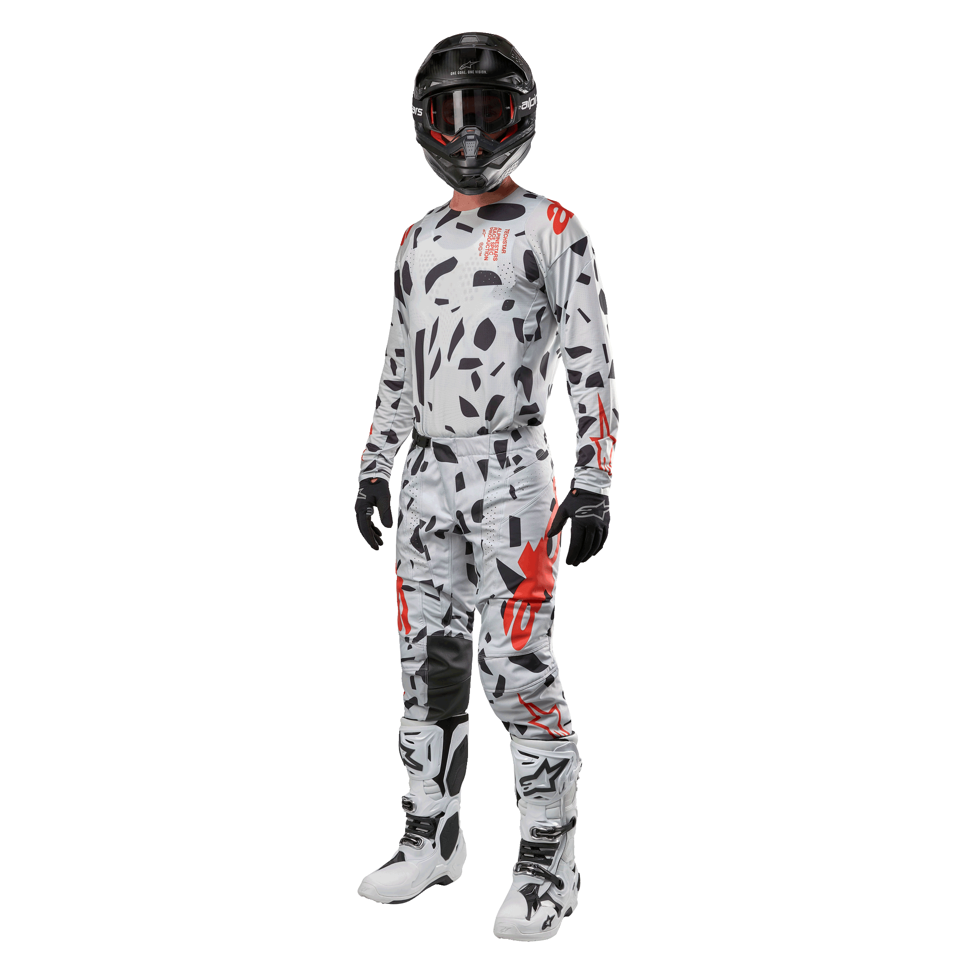 Pilota di motocross con maglia Alpinestars 2024 Techstar Rantera in Haze Gray Camo, pantaloni coordinati con accenti rossi e neri, casco e occhiali neri, guanti neri, stivali bianchi e neri, abbigliamento completo da motocross per prestazioni off-road