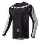 Alpinestars Maglia Techstar Pneuma 2024, maglia da motocross, Dark Sand e Iron Dust Gray, corpo principale nero con pannelli sulle maniche grigio chiaro, logo Alpinestars bianco sul petto, perforazioni di ventilazione tagliate al laser, abbigliamento tecnico per il fuoristrada