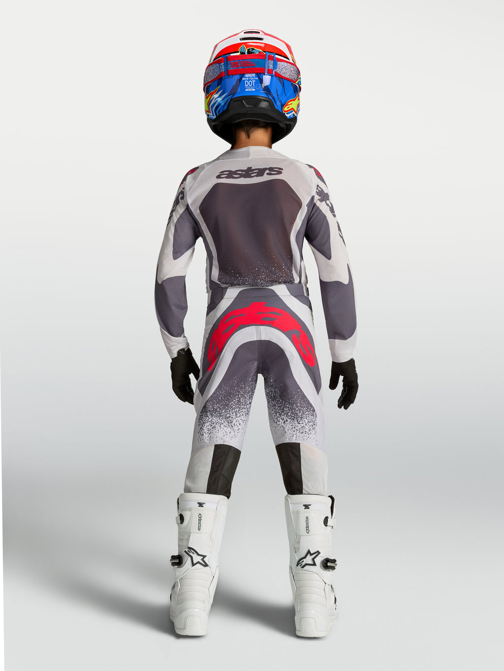 Alpinestars maglia e gear set Supertech Swan ragazzo 2027, completo motocross grigio e bianco con dettagli rossi, vista posteriore, mesh traspirante e vestibilità race fit.