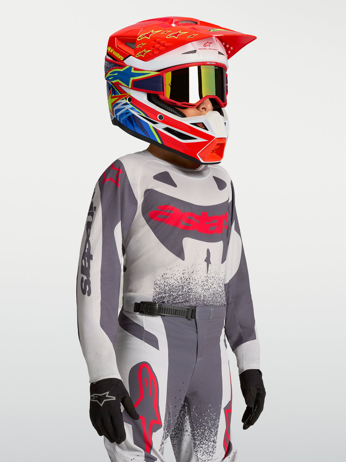 Alpinestars Maglia Supertech Swan Ragazzo e Gear Set 2027, completo motocross grigio e rosso per giovani piloti off-road.