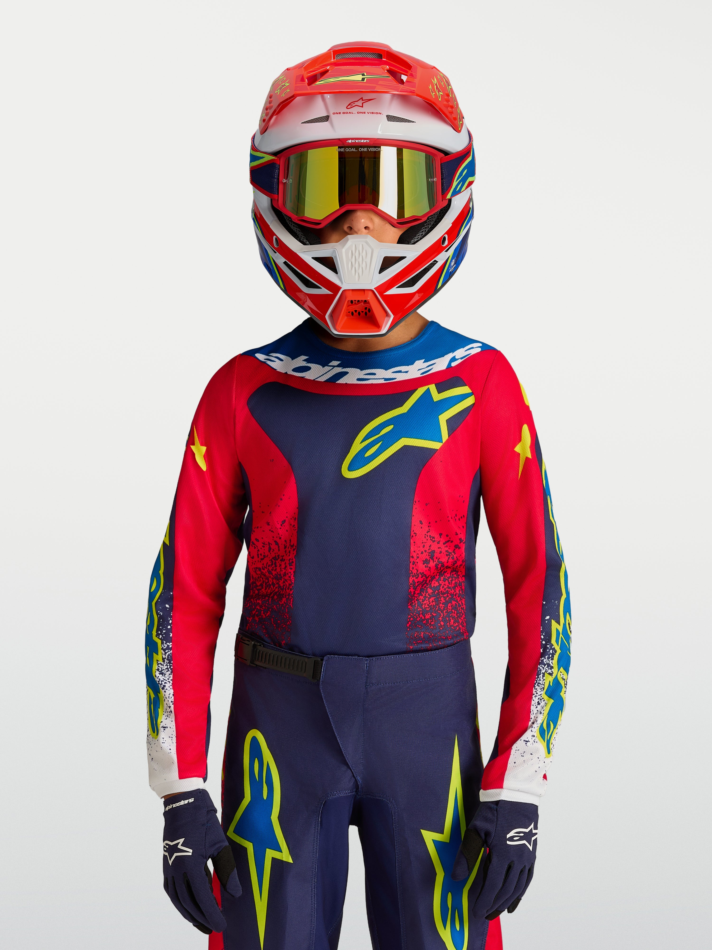 Alpinestars Maglia Fluid Drag ragazzo 2027, maglia da motocross blu navy e rossa con dettagli gialli indossata da un pilota.