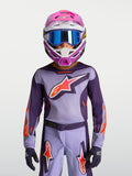 Alpinestars Maglia Fluid Hunt Ragazzo 2027, maglia da motocross viola e rosa fluo, indossata con casco e maschera racing.