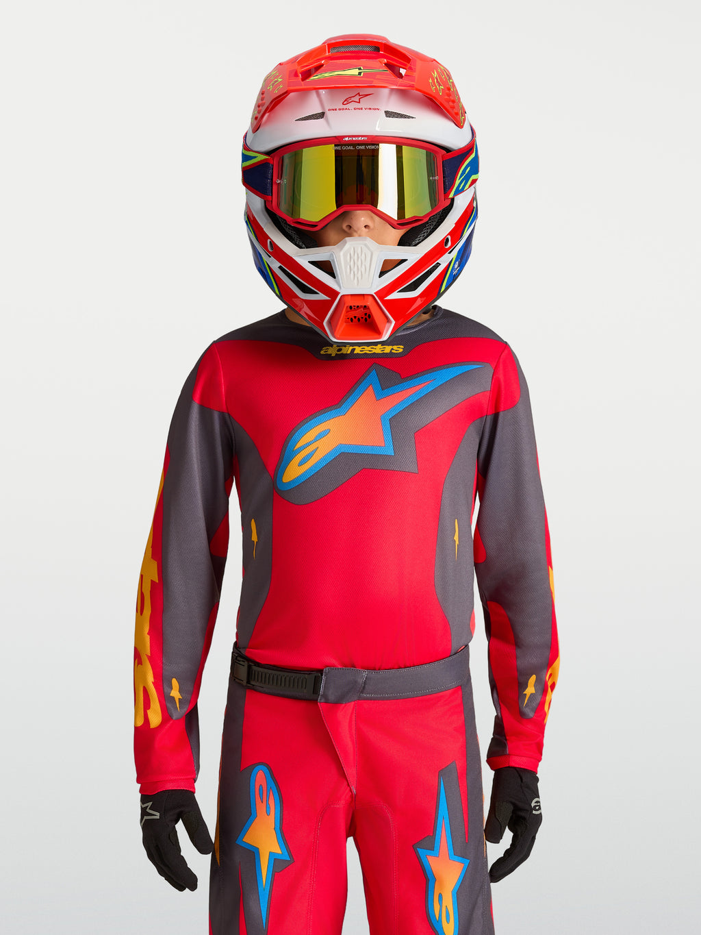 Alpinestars maglia Fluid Hunt ragazzo 2027, maglia da motocross per ragazzi, rosso e grigio, indossata con casco da corsa.