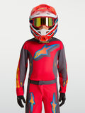 Alpinestars maglia Fluid Hunt ragazzo 2027, maglia da motocross per ragazzi, rosso e grigio, indossata con casco da corsa.