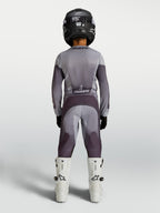 Alpinestars Maglia Fluid Amber Ragazzo 2027 e gear set, completo da motocross grigio e viola, vista posteriore su pilota.