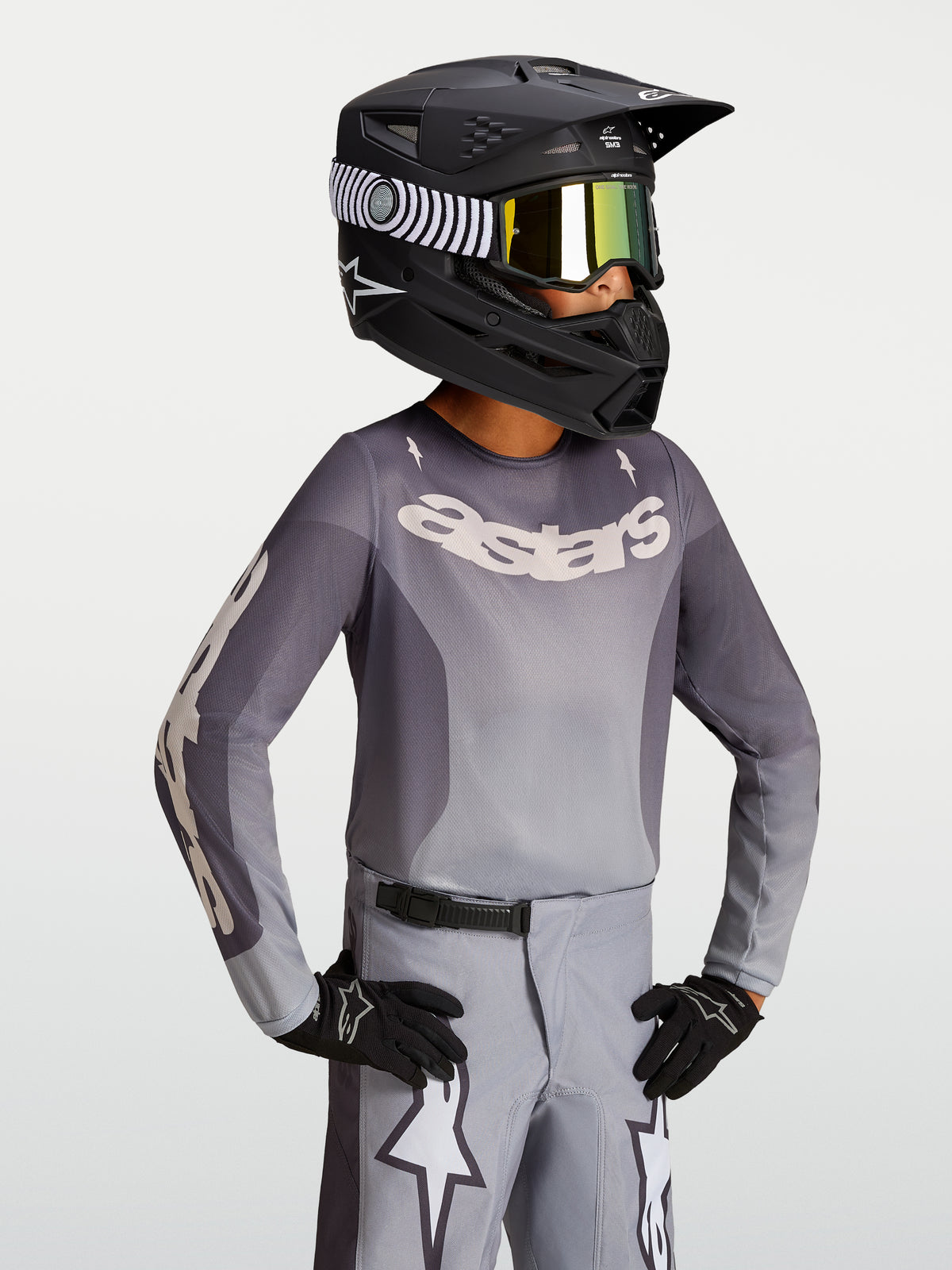 Alpinestars Maglia Fluid Amber Ragazzo 2027, maglia da motocross per ragazzi sabbia e grigia con casco da corsa nero off-road
