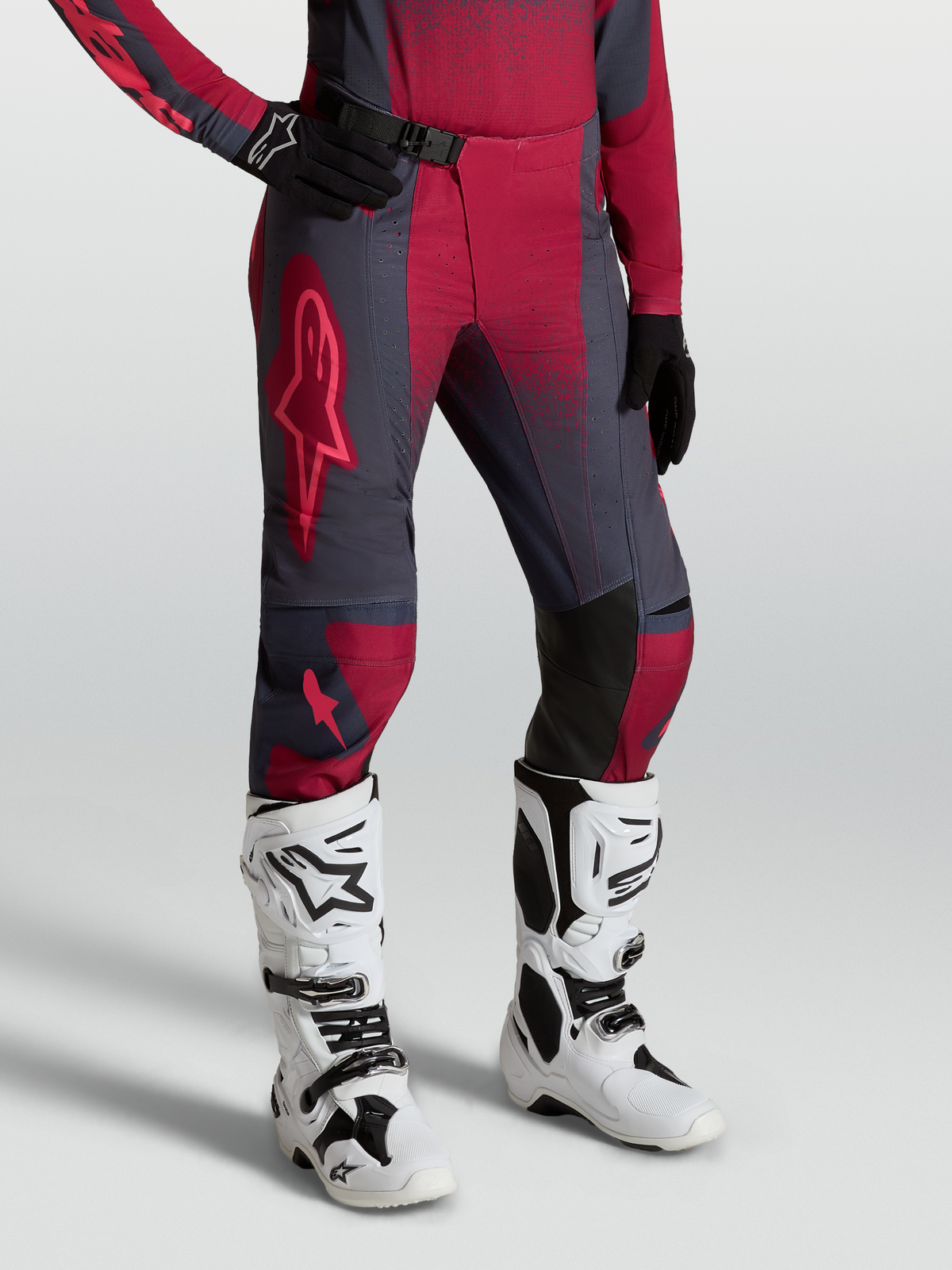 Alpinestars Stella Techstar Swan, pantaloni da motocross da donna, rosso e grigio scuro, con stivali Tech 10 bianchi.