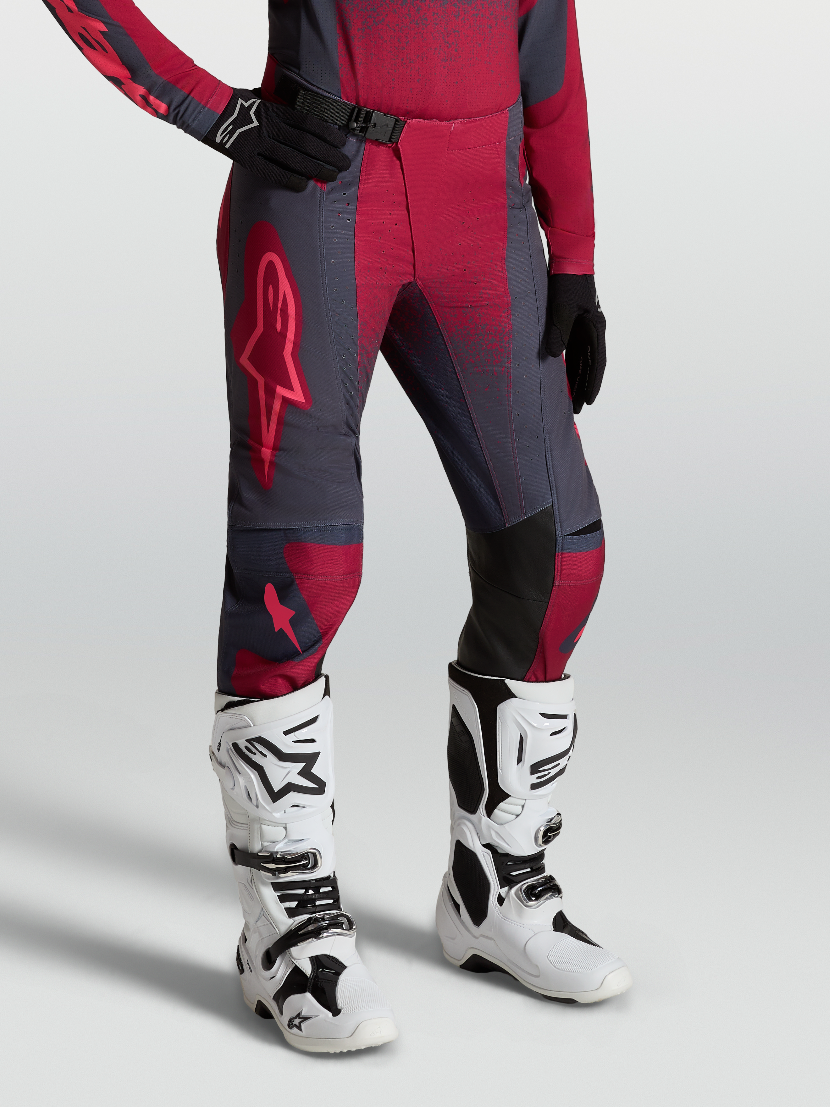 Alpinestars Stella Techstar Swan, pantaloni da motocross da donna, rosso e grigio scuro, con stivali Tech 10 bianchi.