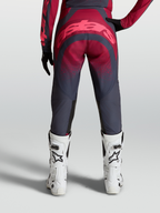 Alpinestars Pantaloni Stella Techstar Swan, pantaloni motocross da donna, grigio e cremisi, vista posteriore su modella con stivali bianchi, abbigliamento off-road ad alte prestazioni.