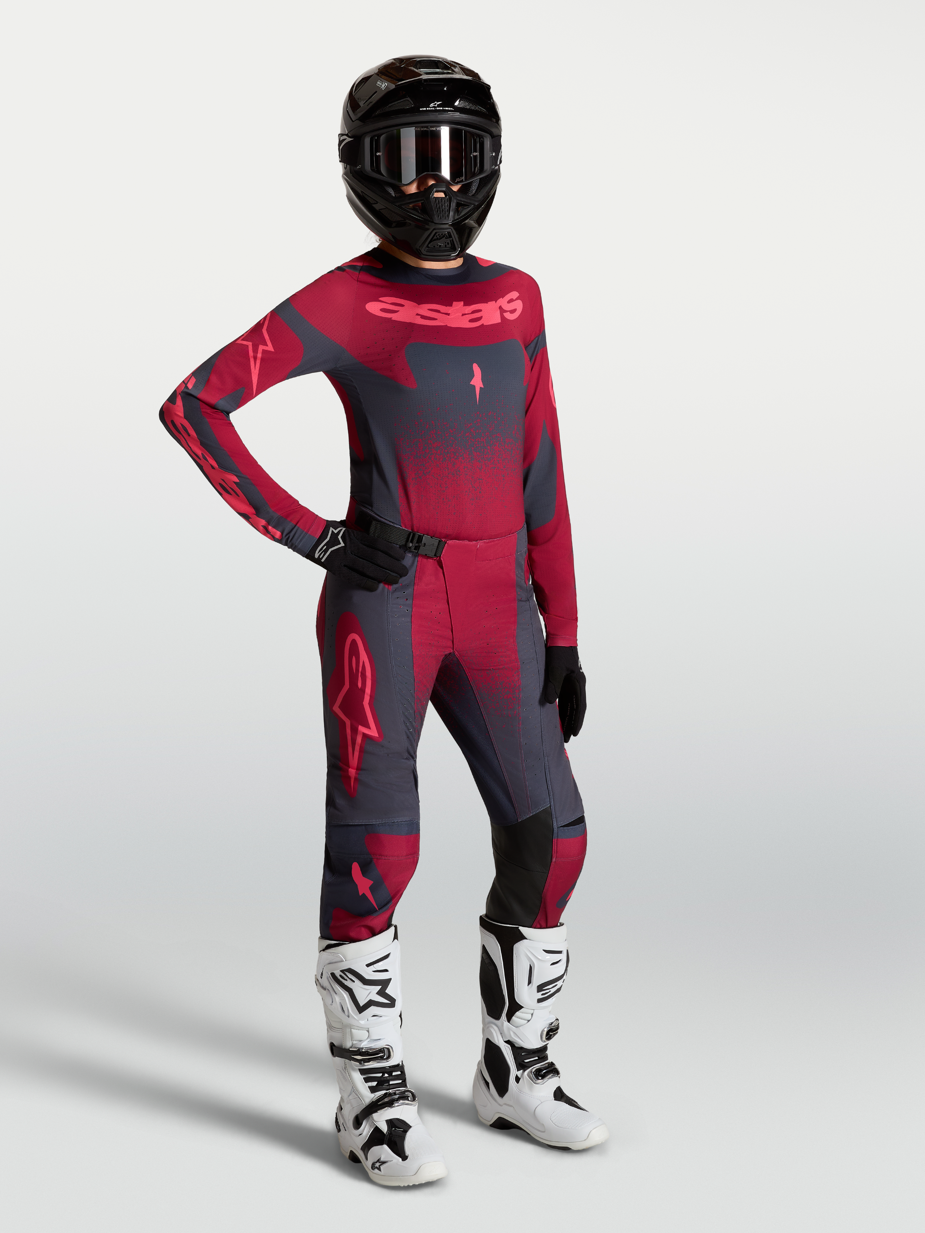 Alpinestars Stella Techstar Swan Maglia e Gear Set, completo motocross da donna, rosso e grigio scuro, con stivali bianchi.
