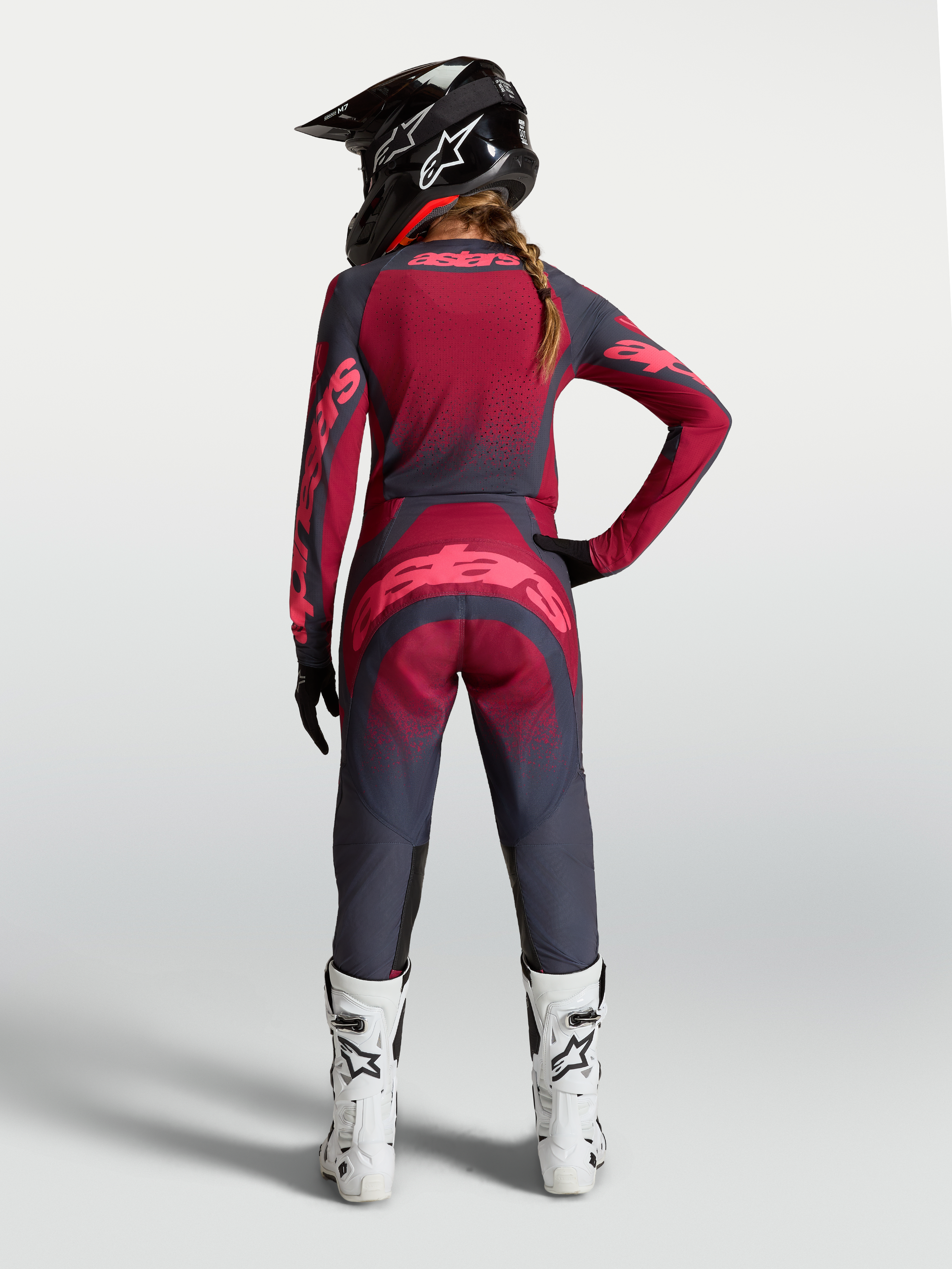 Alpinestars maglia Stella Techstar Swan, completo da motocross da donna rosso e grigio scuro, vista posteriore su modella.
