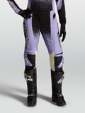 Alpinestars Stella Techstar Swan, pantaloni motocross da donna, viola chiaro e nero, con interni ginocchia in pelle crema, abbinati a stivali neri.