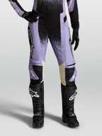 Alpinestars Stella Techstar Swan, pantaloni motocross da donna, viola chiaro e nero, con interni ginocchia in pelle crema, abbinati a stivali neri.