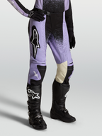 Alpinestars Pantaloni Stella Techstar Swan, pantaloni da motocross per donna, viola e nero, pannelli ginocchio in pelle bianca, indossati con stivali neri, abbigliamento fuoristrada premium