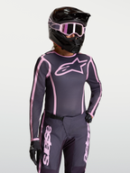 Alpinestars maglia Stella Fluid Apex V2, maglia da motocross da donna, grigio e rosa, tessuto traspirante con vestibilità ergonomica per prestazioni off-road, indossata con equipaggiamento coordinato.