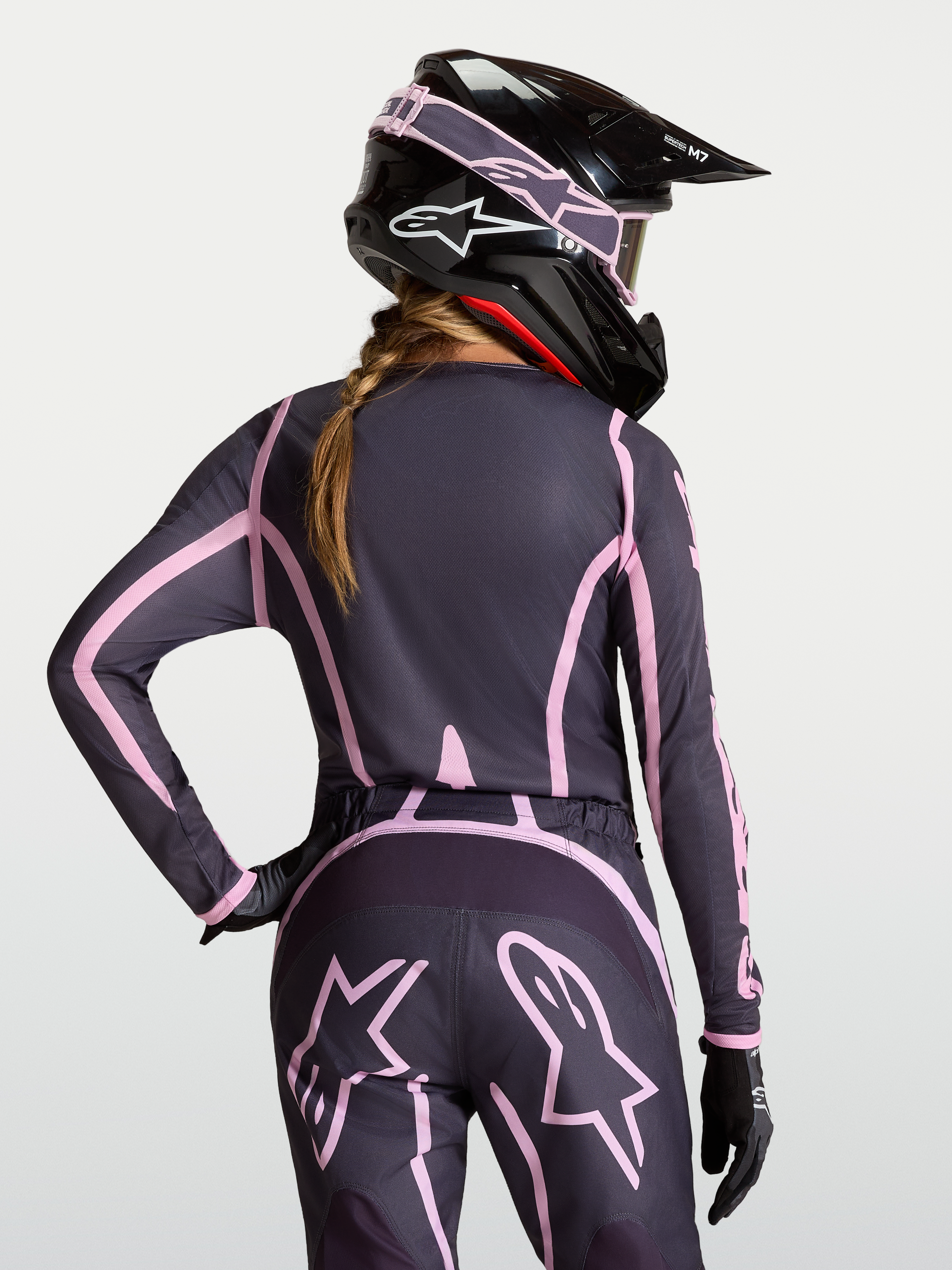 Alpinestars Maglia Stella Fluid Apex V2, maglia motocross da donna, grigio e rosa, vestibilità ergonomica con retro allungato, indossata con casco coordinato, abbigliamento tecnico off-road