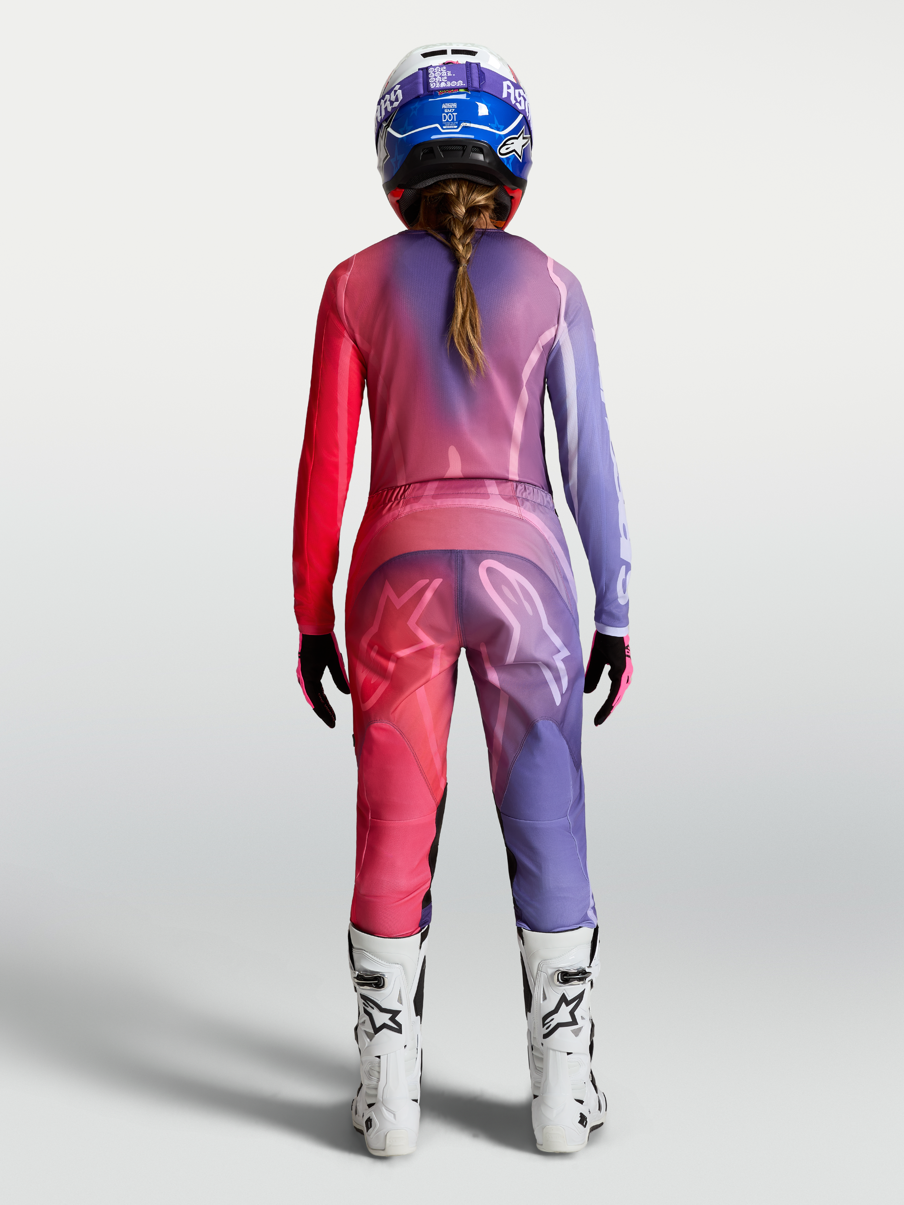 Alpinestars Maglia Stella Fluid Kepler, maglia da motocross per donna, viola e rosso, in poliestere traspirante, vista posteriore su modella con pantaloni e stivali coordinati.