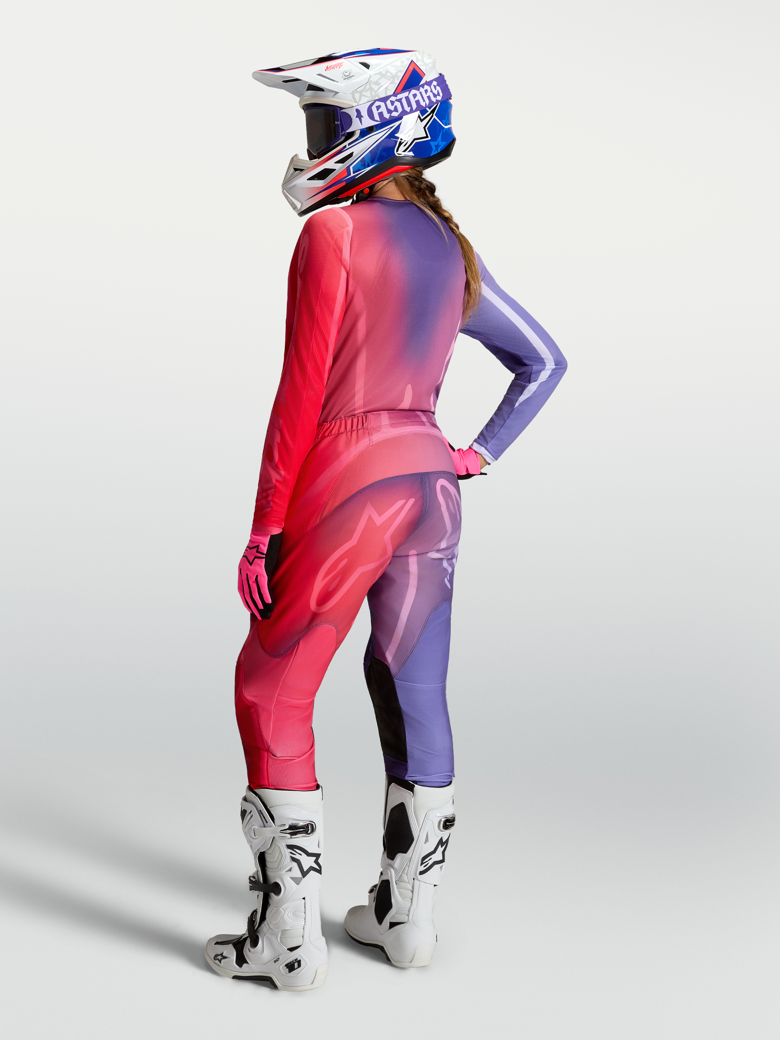 Alpinestars Maglia Stella Fluid Kepler, maglia da motocross per donna, viola e rosso, indossata con pantaloni e stivali coordinati, vista posteriore, tessuto traspirante per performance off-road